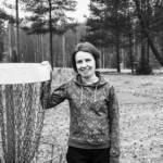 Annika Nyström pitää kättään frisbeegolfkorin reunalla ja nauraa.